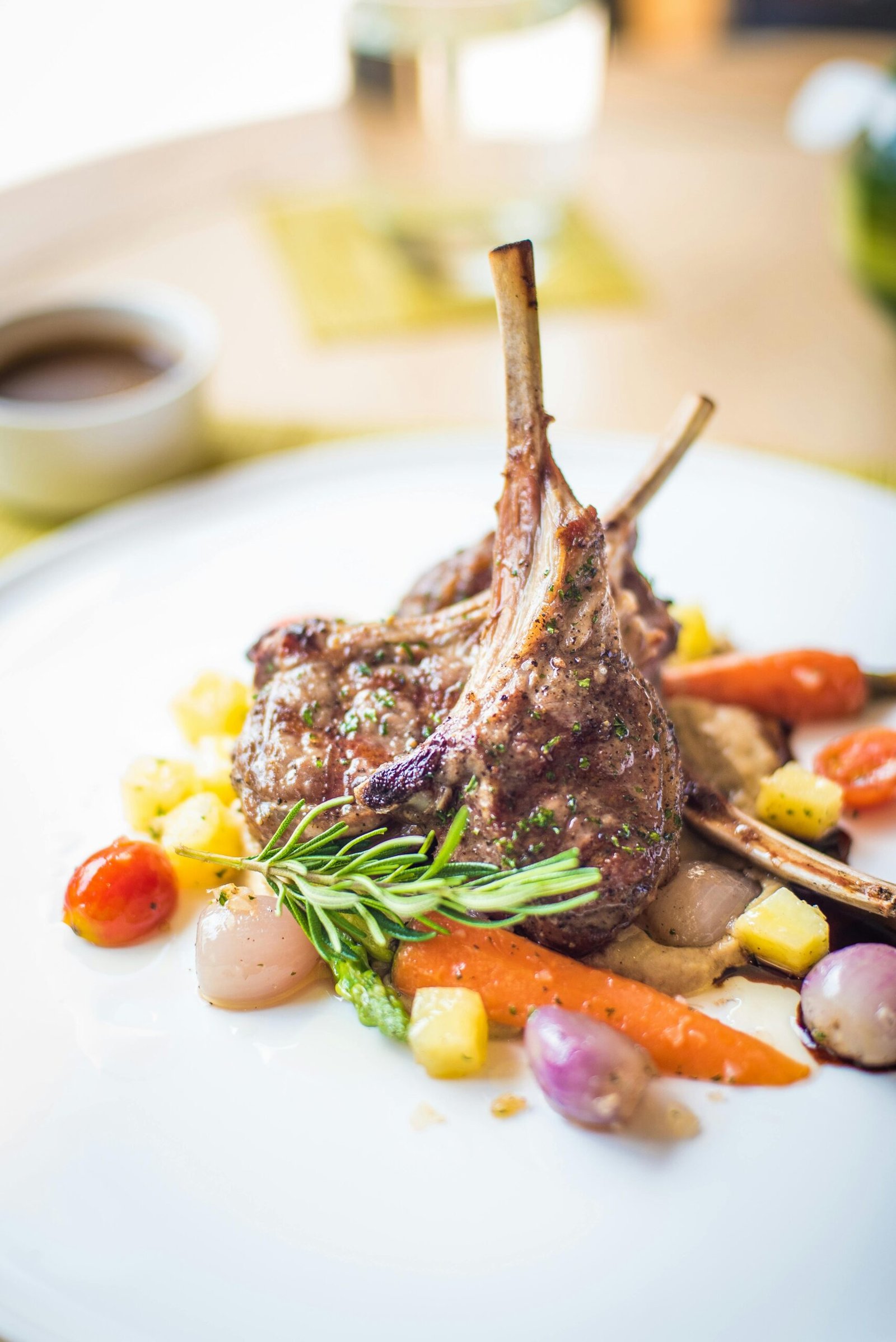 Exquisite plated lamb chops with colorful vegetables, showcasing fine gastronomy.