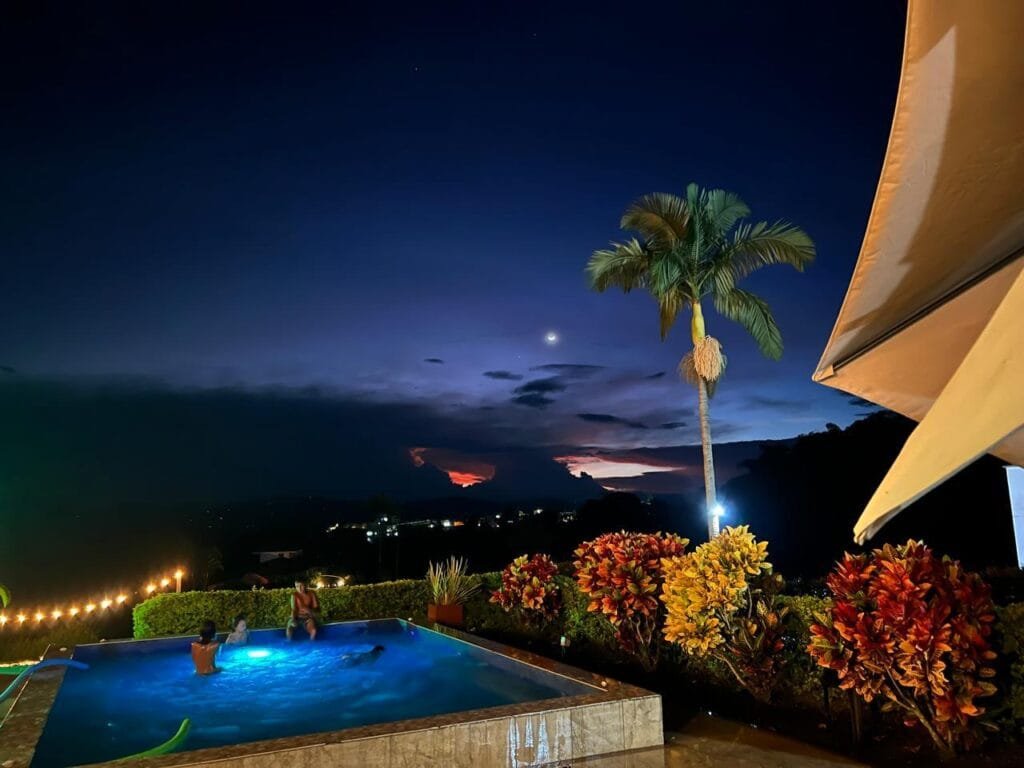 Piscina de la Finca Hotel Villa Flor en Quimbaya al atardecer, con vista panorámica al paisaje del Eje Cafetero