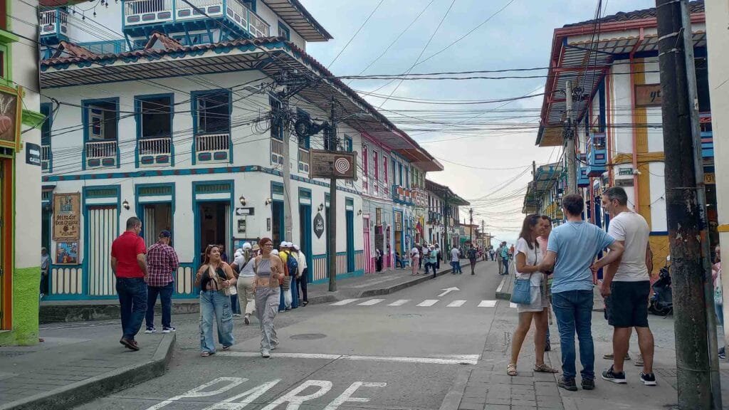 Calle colorida de Filandia, Quindío, con arquitectura colonial antioqueña, balcones de madera y turistas caminando